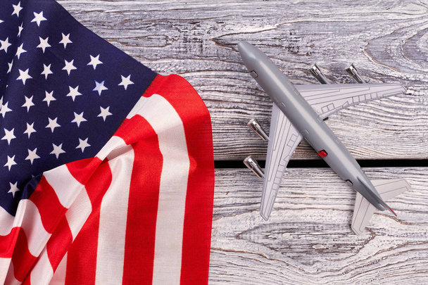 Πλαστικό παιχνίδι αεριωθούμενο αεροπλάνο και σημαία των ΗΠΑ. - Φωτογραφία, εικόνα