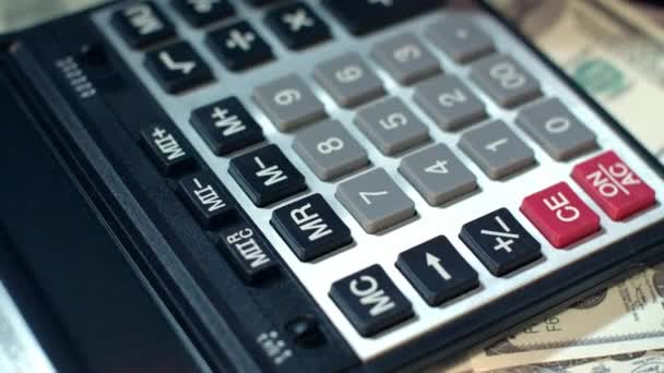 Mano di donna d'affari usando la calcolatrice all'ufficio. Calcolatrice sulle banconote in dollari
 - Filmati, video