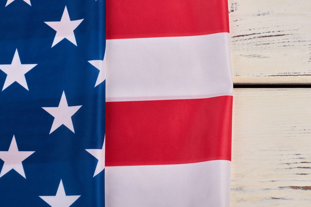 Αμερικανική σημαία που διπλώνονται σε άσπρο φόντο ξύλινη. - Φωτογραφία, εικόνα