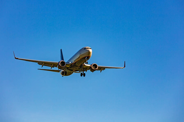 Duży samolot pasażerski lecący na niebieskim niebie - Zdjęcie, obraz