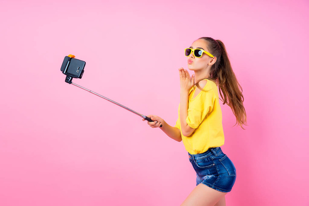 Smiling teenage girl making selfie with stick - Zdjęcie, obraz
