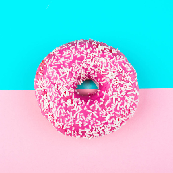 Minimalism, colour contrast on a blue and pink background, donut photo from above in flat style - Foto, immagini