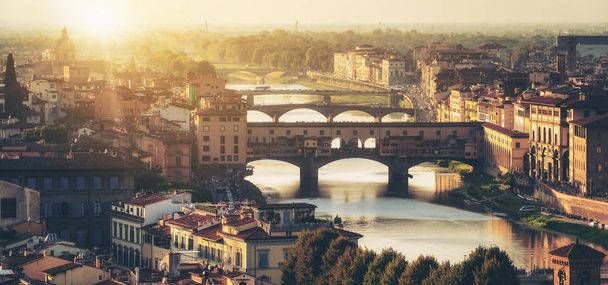 Γέφυρα Ponte Vecchio της Φλωρεντίας και στον ορίζοντα της πόλης στην Ιταλία. Η Φλωρεντία είναι πρωτεύουσα της περιφέρειας της Τοσκάνης της κεντρικής Ιταλίας. Φλωρεντία ήταν μεσαιωνικό εμπορικό κέντρο της Ιταλίας και πλουσιότερες πόλεις της περασμένης εποχής. - Φωτογραφία, εικόνα