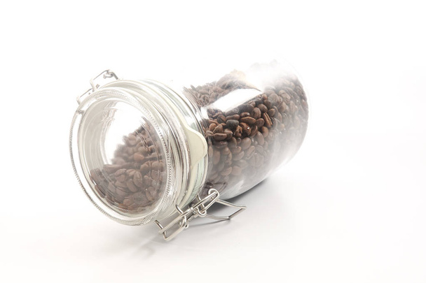 Raw coffee bean in a mason jar over white background - Photo, image