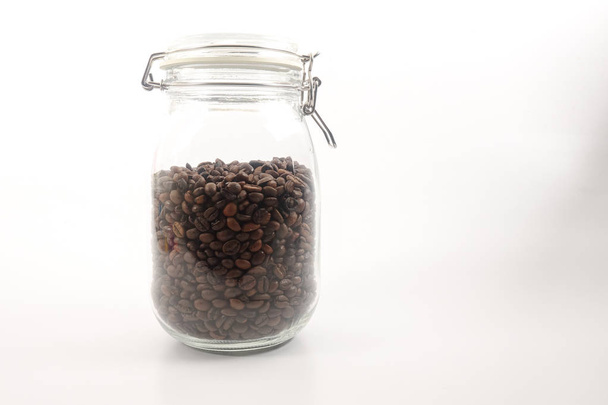 Raw coffee bean in a mason jar over white background - Foto, Bild