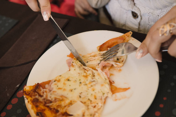Мама и дети едят пиццу в кафе
 - Фото, изображение