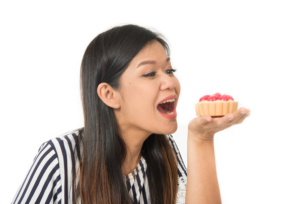 Ασιατικές γυναίκα τρώει τούρτα επιδόρπιο γλυκά τρόφιμα σε λευκό φόντο - Φωτογραφία, εικόνα