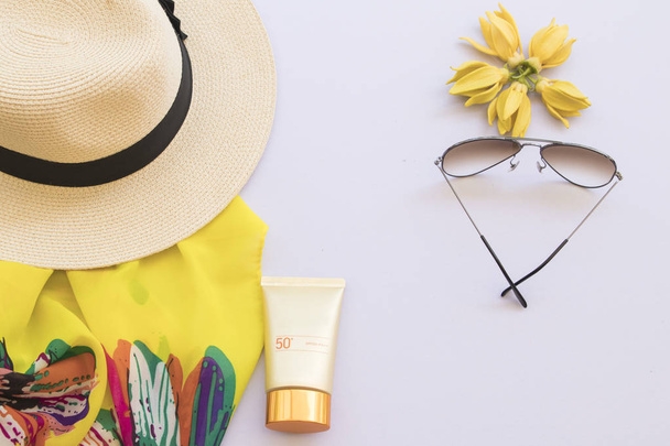 natuurlijke cosmetica voor huid gezicht zonnecrème spf50 en accessoires van lifestyle vrouw ontspannen zomer met ylang ylang bloemstuk op witte achtergrond - Foto, afbeelding