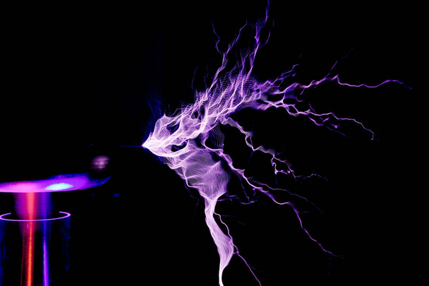 Tesla-Spule, elektrostatische Entladung, Funke, Blitz auf schwarzem Hintergrund  - Foto, Bild