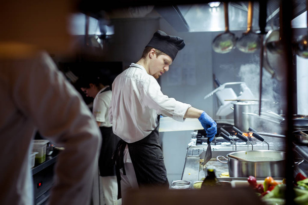 Chef working on the kitchen - Фото, изображение