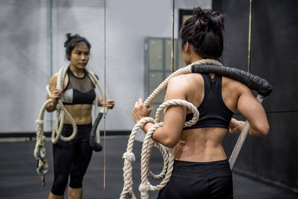 Jeune femme asiatique gymnaste portant des cordes sur les épaules pour l'exercice de gymnastique dans la salle de fitness
 - Photo, image