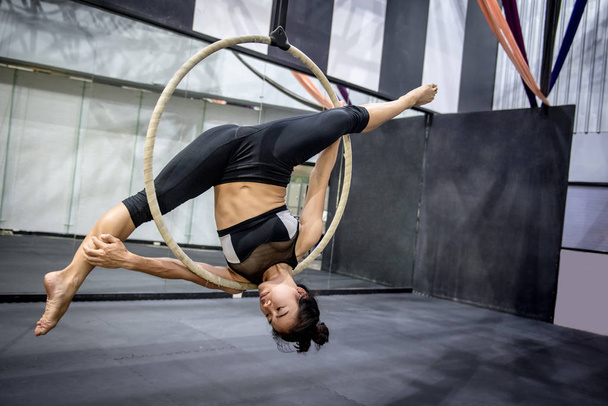 giovane asiatica acrobatica donna facendo la sua performance ginnica sul cerchio aereo o anello aereo
 - Foto, immagini