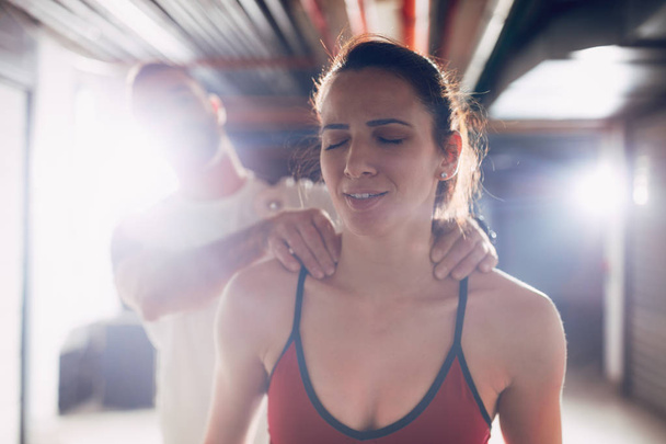 Молодий менеджмент масажу шиї втомленого друга після тренування
 - Фото, зображення