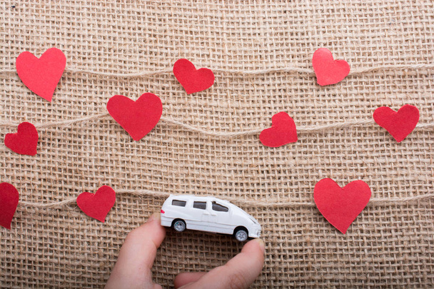Love concept with car and paper heart on linen threads - Photo, Image