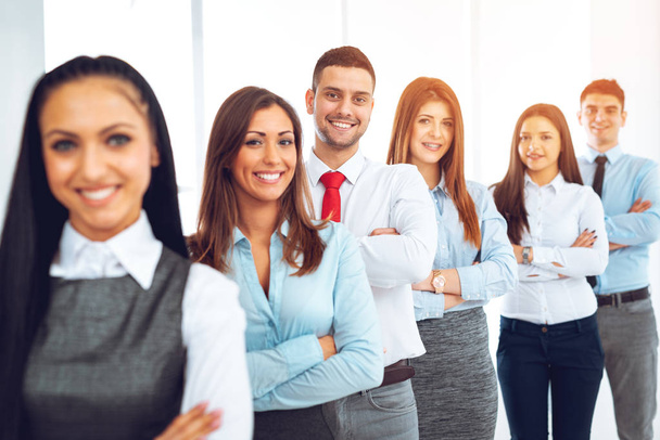 Smiling group of young business people standing with arms crossed and posing at camera - Photo, Image