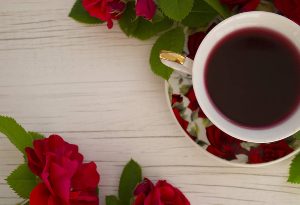 cup of red tea with roses on a light background - Photo, Image