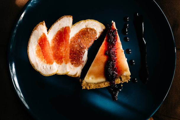 delicious Cheesecake with grapefruit slices on plate - Фото, зображення