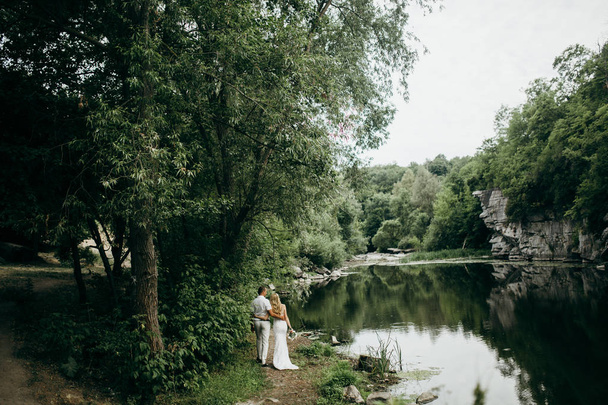  young couple of newlyweds by lake  - Valokuva, kuva
