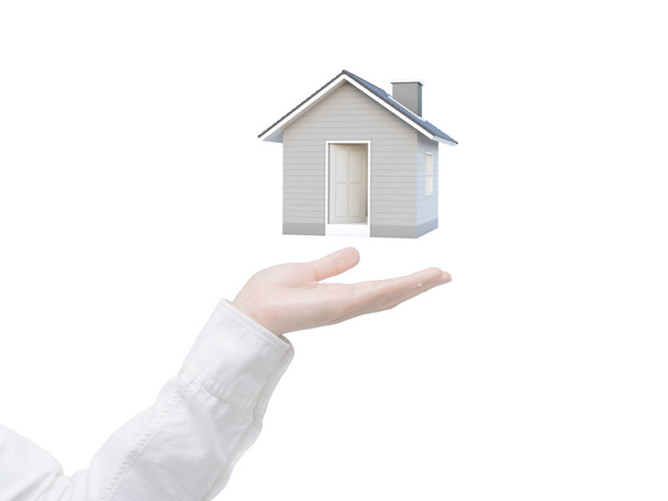 Mano femenina que muestra la casa 3D aislada sobre fondo blanco con camino de recorte. Idea de imagen de bienes raíces y concepto de propiedad. Representación House 3D
. - Foto, imagen
