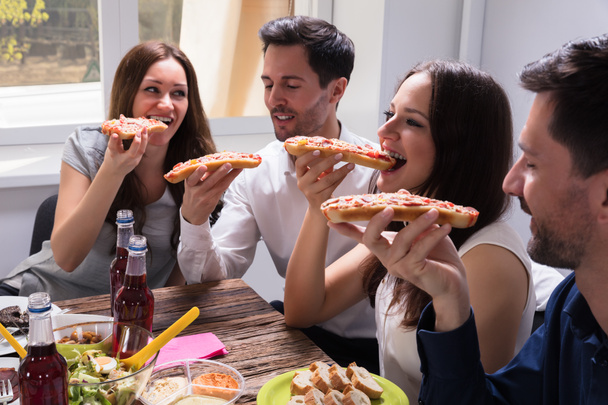 Portrait de jeunes amis heureux mangeant délicieux frais Bruschetta
 - Photo, image