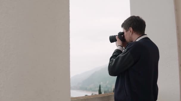 Fotógrafo masculino está assistindo na lente da câmera em uma paisagem
 - Filmagem, Vídeo