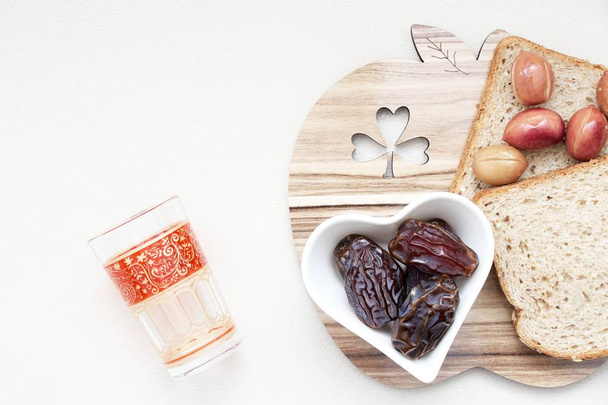 Święto Ramadan Kareem z datą islamskich, z oliwek, szklanka wody, chleba żywności na białym tle - Zdjęcie, obraz