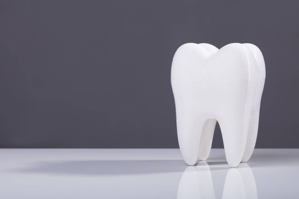 Diente blanco sano dental oral sobre fondo gris
 - Foto, Imagen