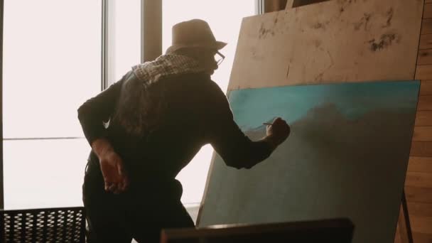 Kunstenaar staat in de buurt van ezel, tekening details van berg op toekomstige foto - Video