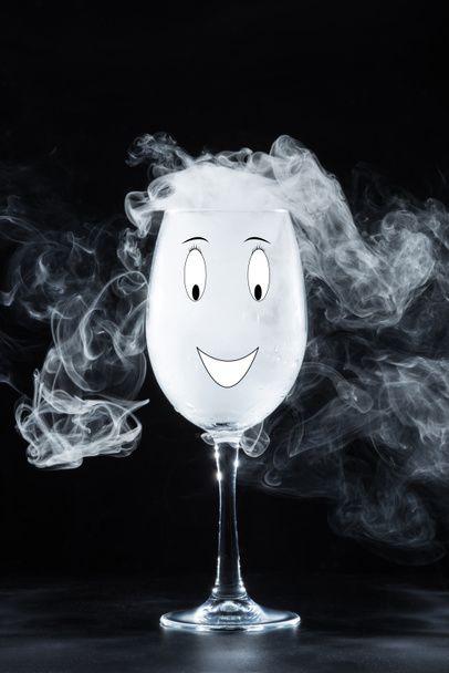 glass with white smoke and smile symbol on black background - Фото, изображение