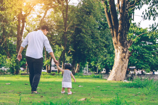 Happy father and little girl walking in summer park. adoption and people concept. - Φωτογραφία, εικόνα