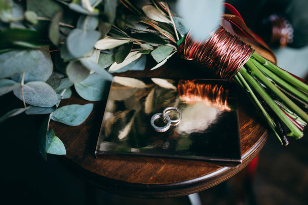 Wedding rings and bouquet, close up - Φωτογραφία, εικόνα