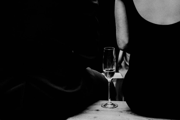 man and woman sitting, glass of wine on bench - Фото, зображення