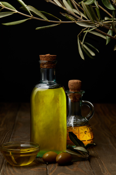 bottles of various olive oil on wooden surface - Φωτογραφία, εικόνα