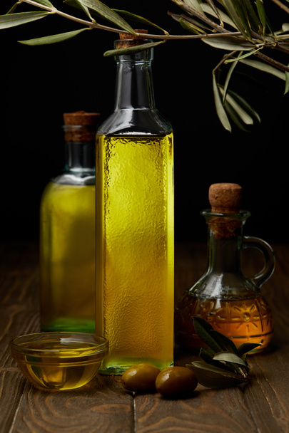 bottles of various olive oil on wooden surface - Foto, Imagen