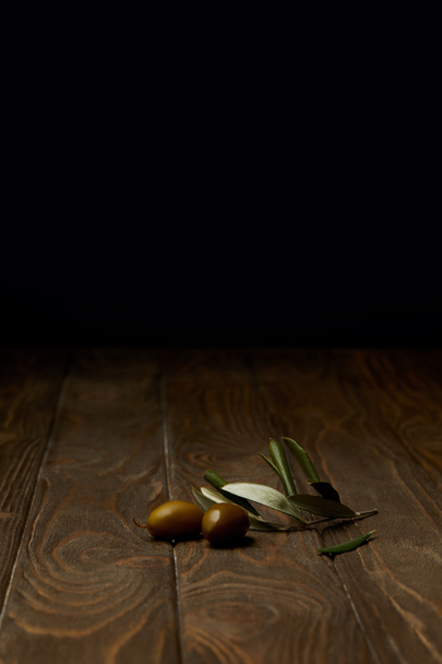 Оливковая ветвь с оливками на деревянной поверхности
 - Фото, изображение