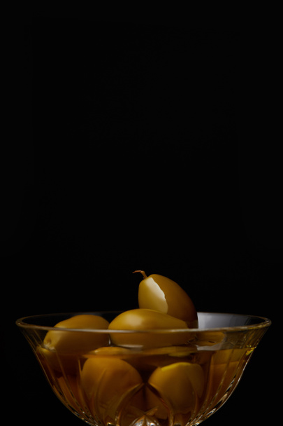 olives dans un bol avec de l'huile isolée sur noir
 - Photo, image