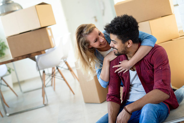 Young married couple Moving in new home and unpacking carboard boxes - Foto, Bild