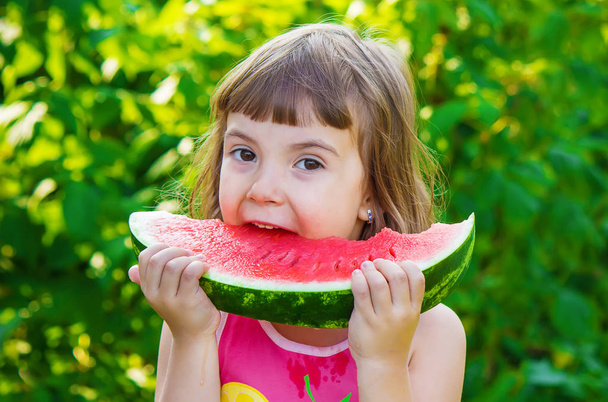 Een kind eet watermeloen. Selectieve aandacht. - Foto, afbeelding