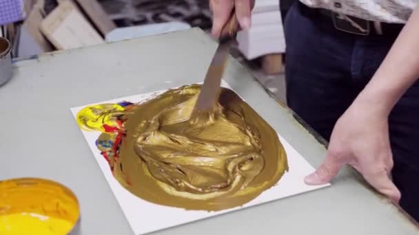 uomo mescola vernice fino a colore dorato, per stampare il logo sui prodotti di imballaggio
 - Filmati, video