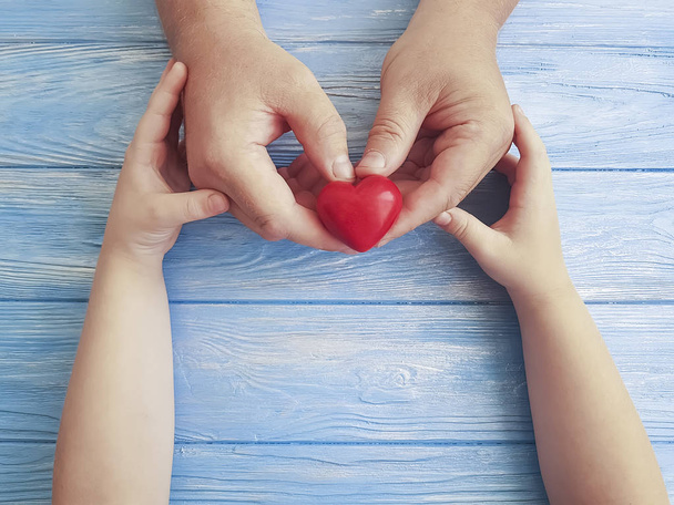 День батька Руки Тато і дитяче серце на синьому дерев'яному тлі
 - Фото, зображення