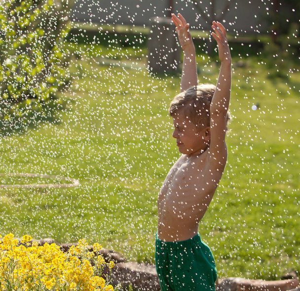 Boy playing outdoors in summer rain. Summer fun - Foto, Imagen