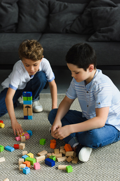 little boys playing with wooden blocks on floor at home - Photo, Image