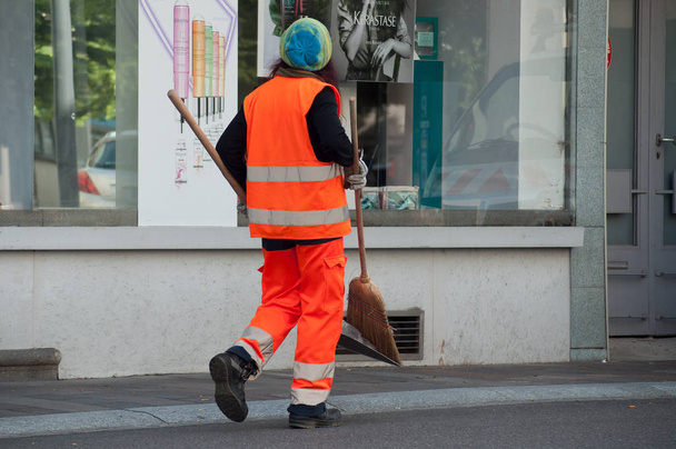 Woman municipal employee walking with shovel and broom in hand - Zdjęcie, obraz