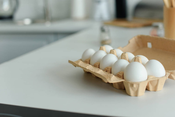 close up view of raw chicken eggs in box on tabletop in kitchen - Photo, Image