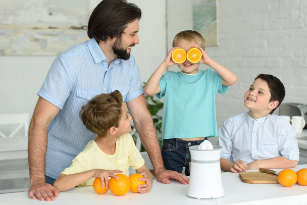 family making fresh orange juice in kitchen at home - Φωτογραφία, εικόνα
