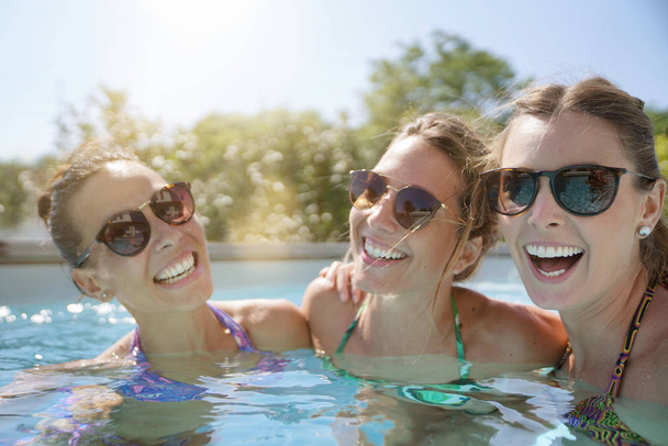 Girls relaxing in swimming pool, sunny day - Photo, Image