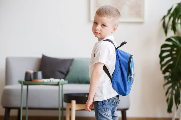 Picture of boy with backpack near sofa - Zdjęcie, obraz