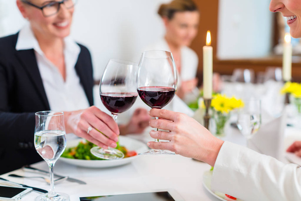 Women on business lunch toasting with wine - 写真・画像