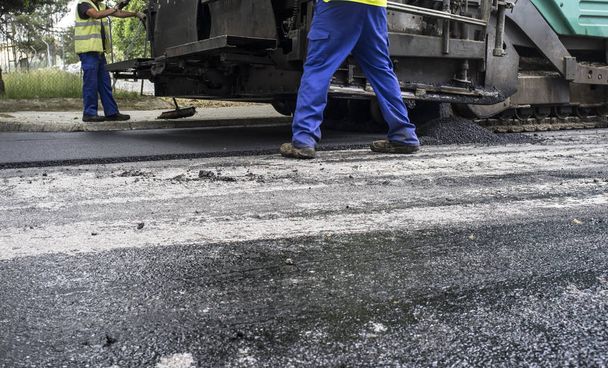 Lavori sulla posa di asfalto in città. Pavimentazione macchina applicatore o pavimentatore con lavoratori
 - Foto, immagini