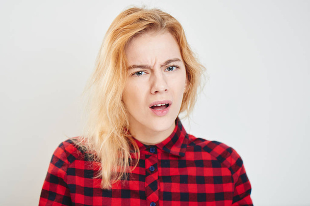 Portrait of young woman in checkered shirt with expression emotions misunderstandings isolated on white background  - Valokuva, kuva